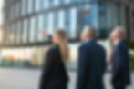agent customers meeting outdoors discussing real property pointing office buildin
